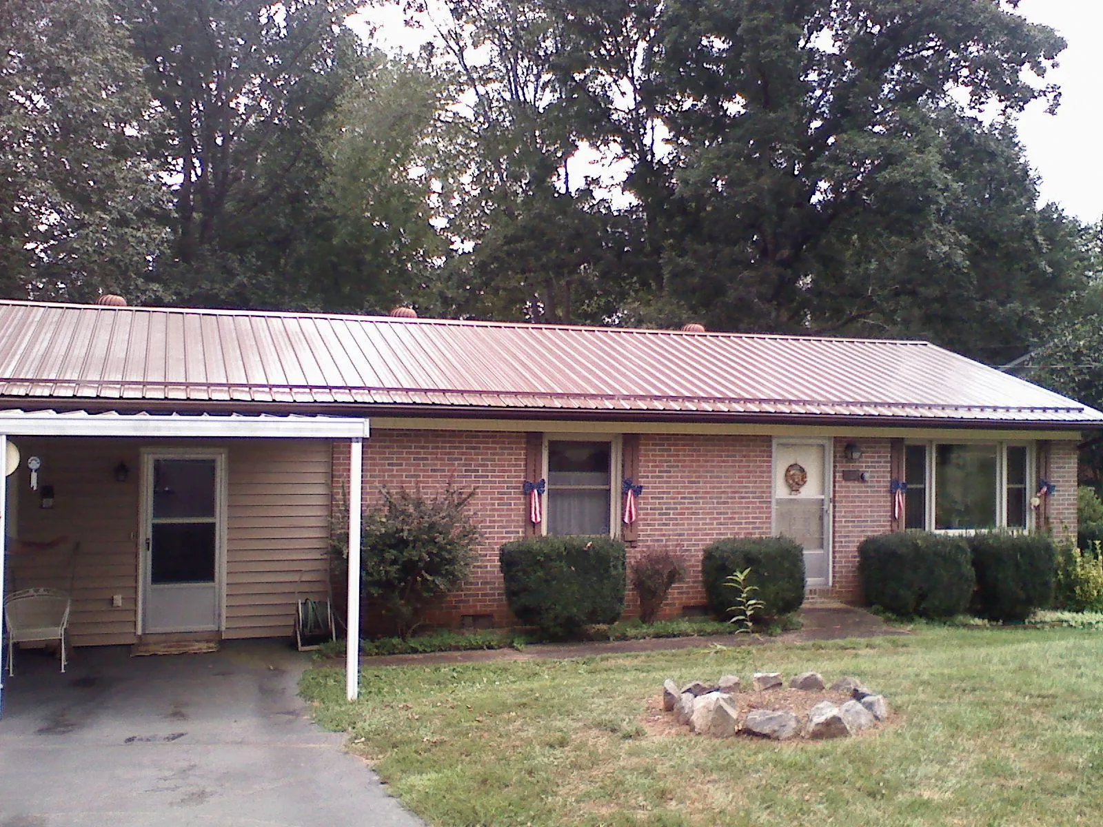 Bronze metal roof and carport on a brick ranch home — Roof Repair work by our crew in Highmore